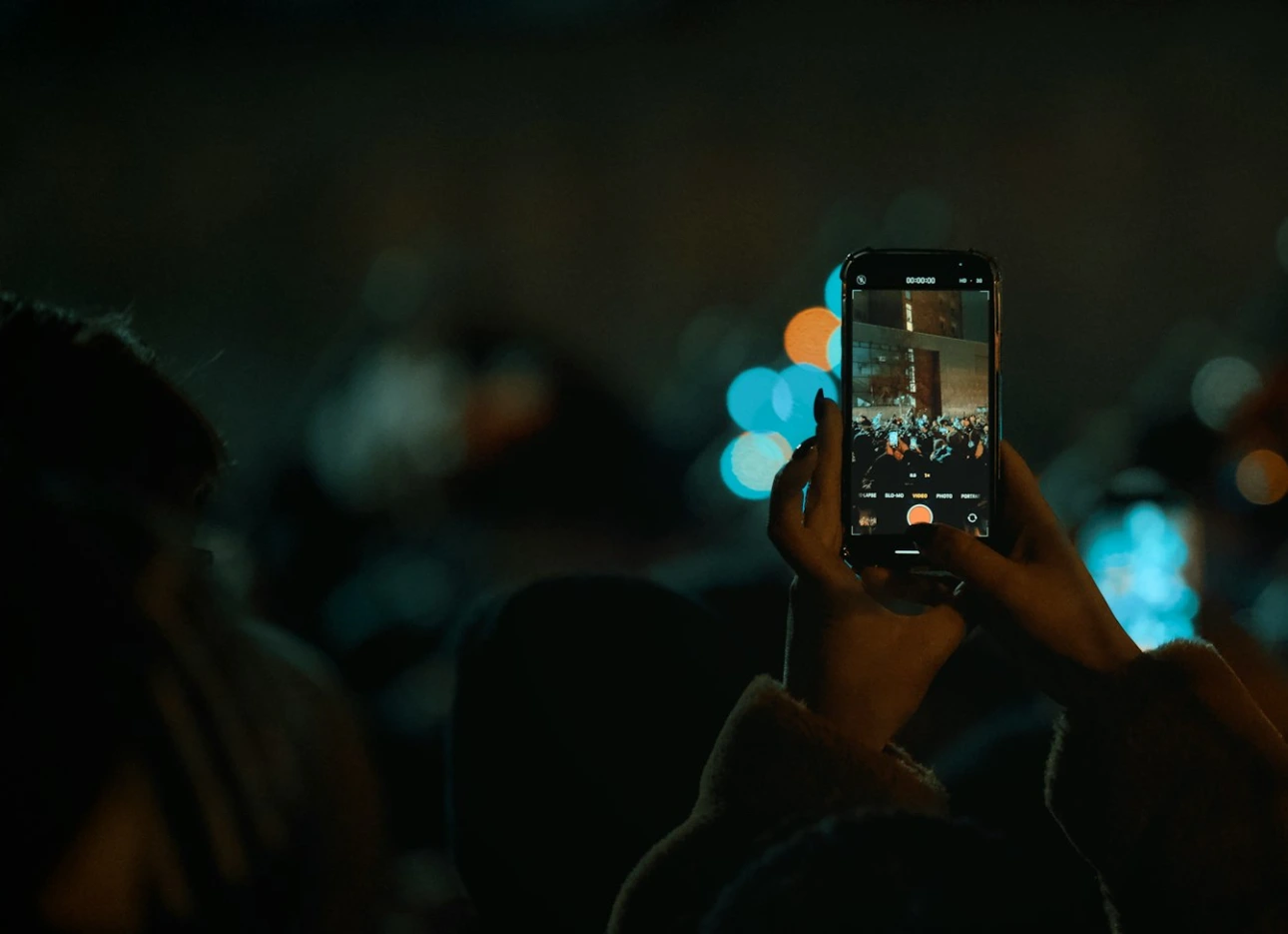 Person records event with smartphone at phone